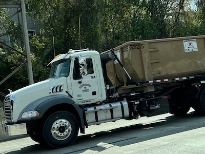 Gainsborough Waste roll-off dumpster being transported on the back of a truck